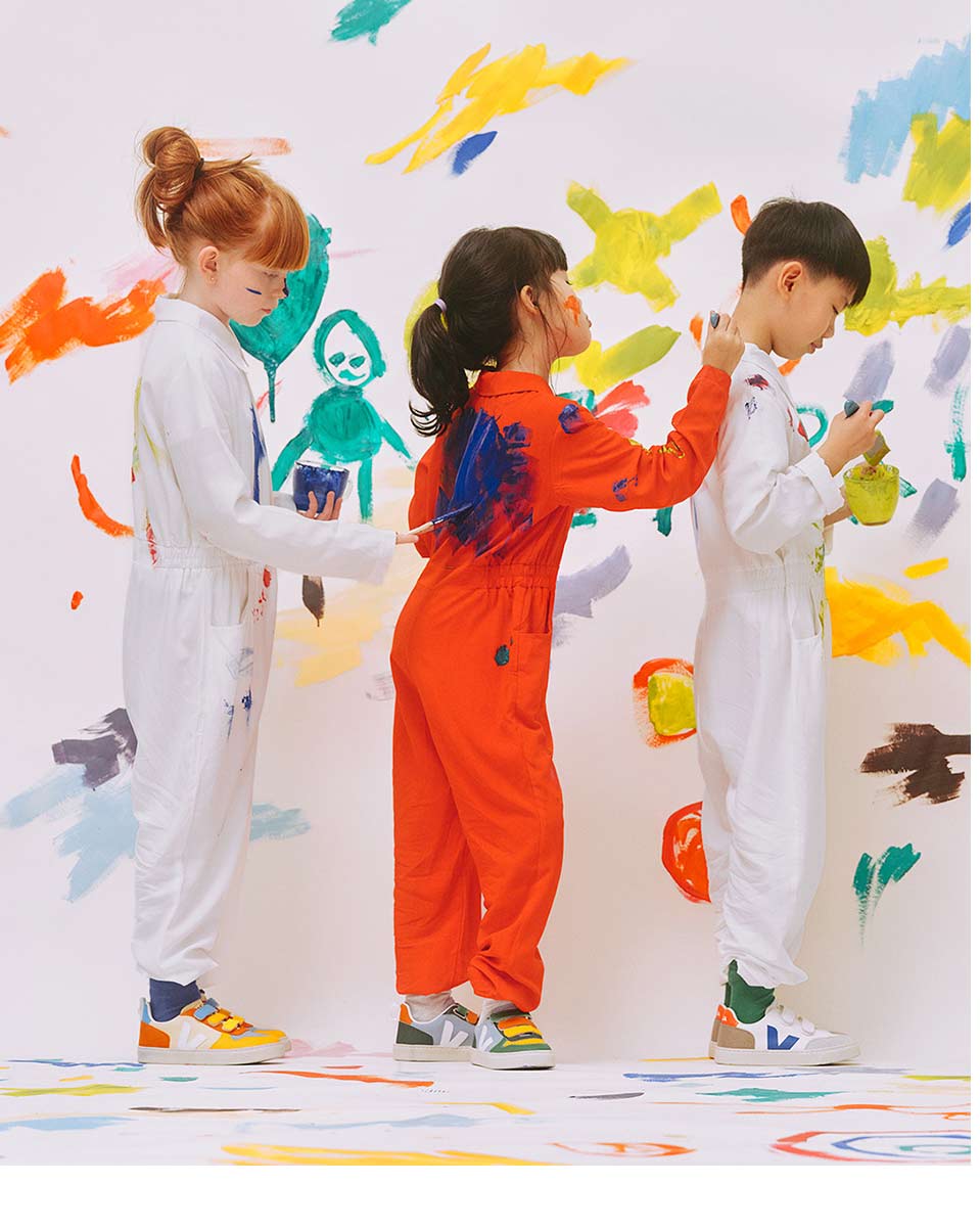 A group of children painting on painters' suits.