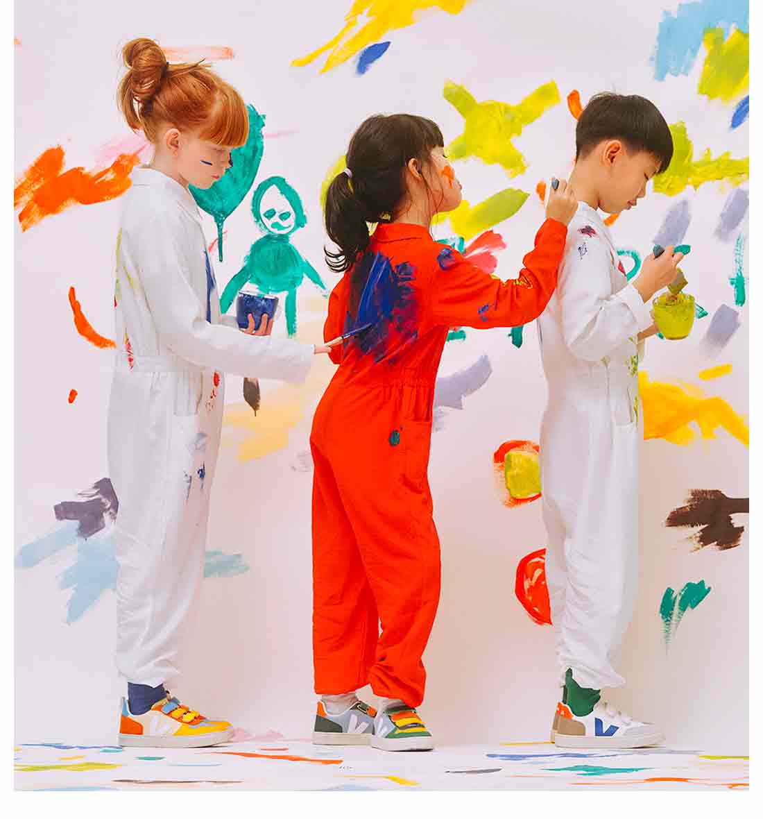 A group of children painting on painters' suits.
