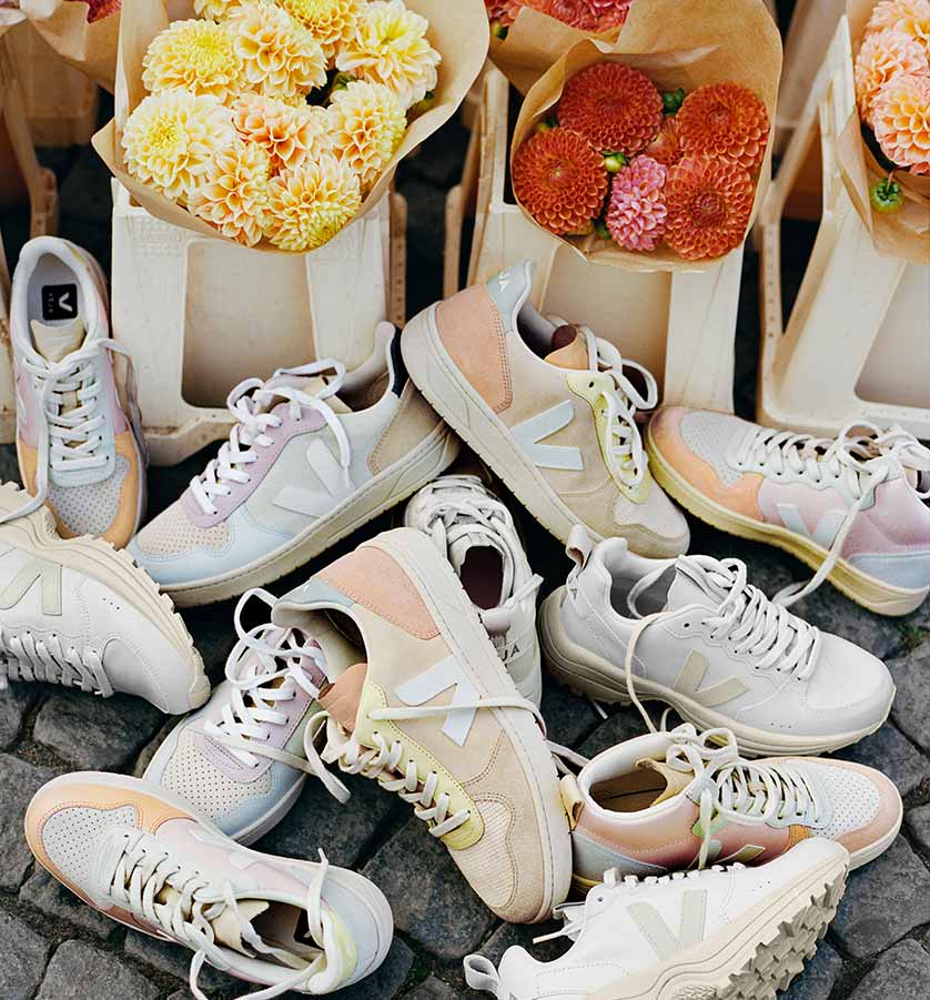 veja sneakers placed on the floor with bouquets of flowers