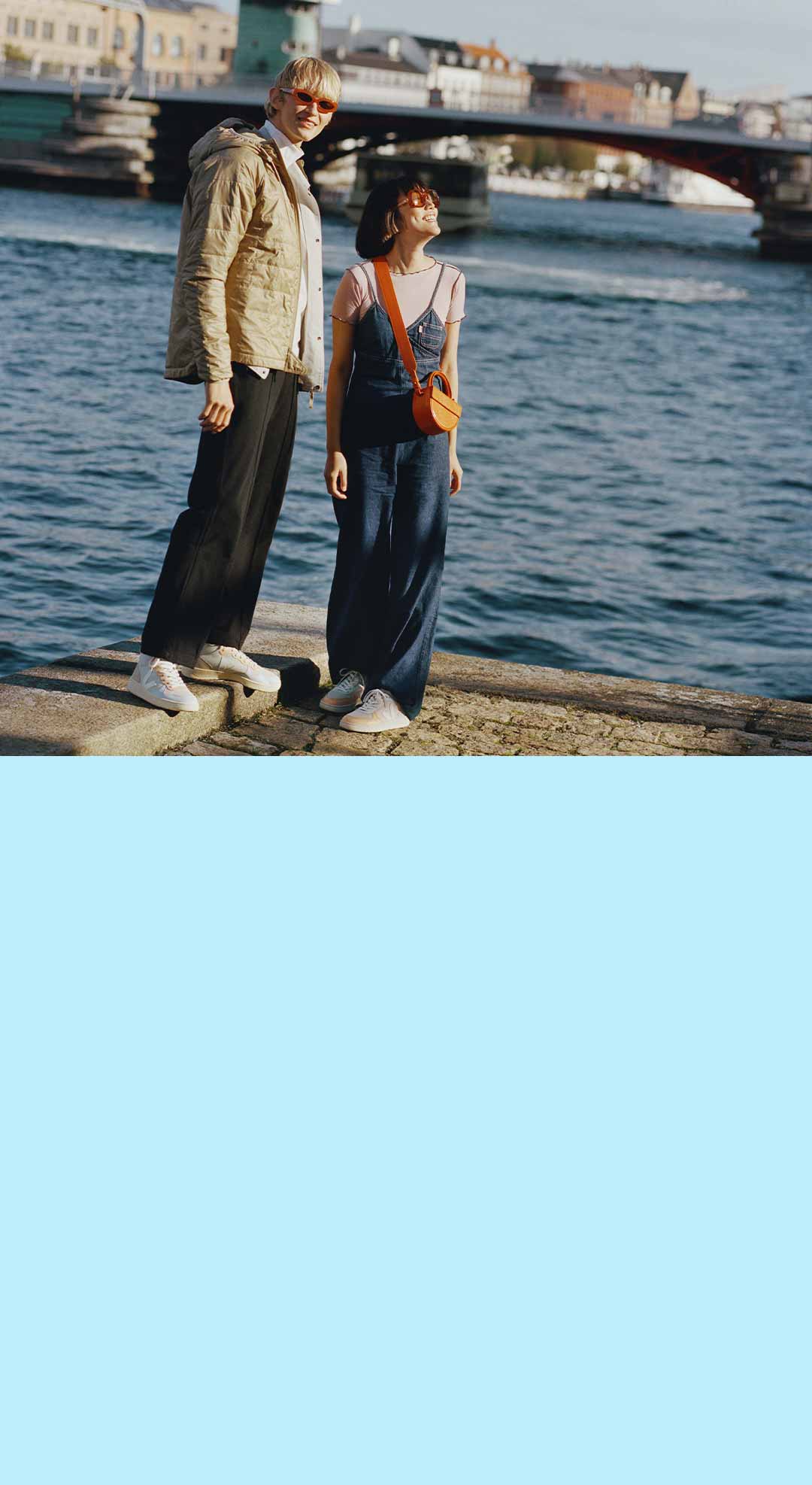 deux personnes portant des baskets VEJA près d'un port