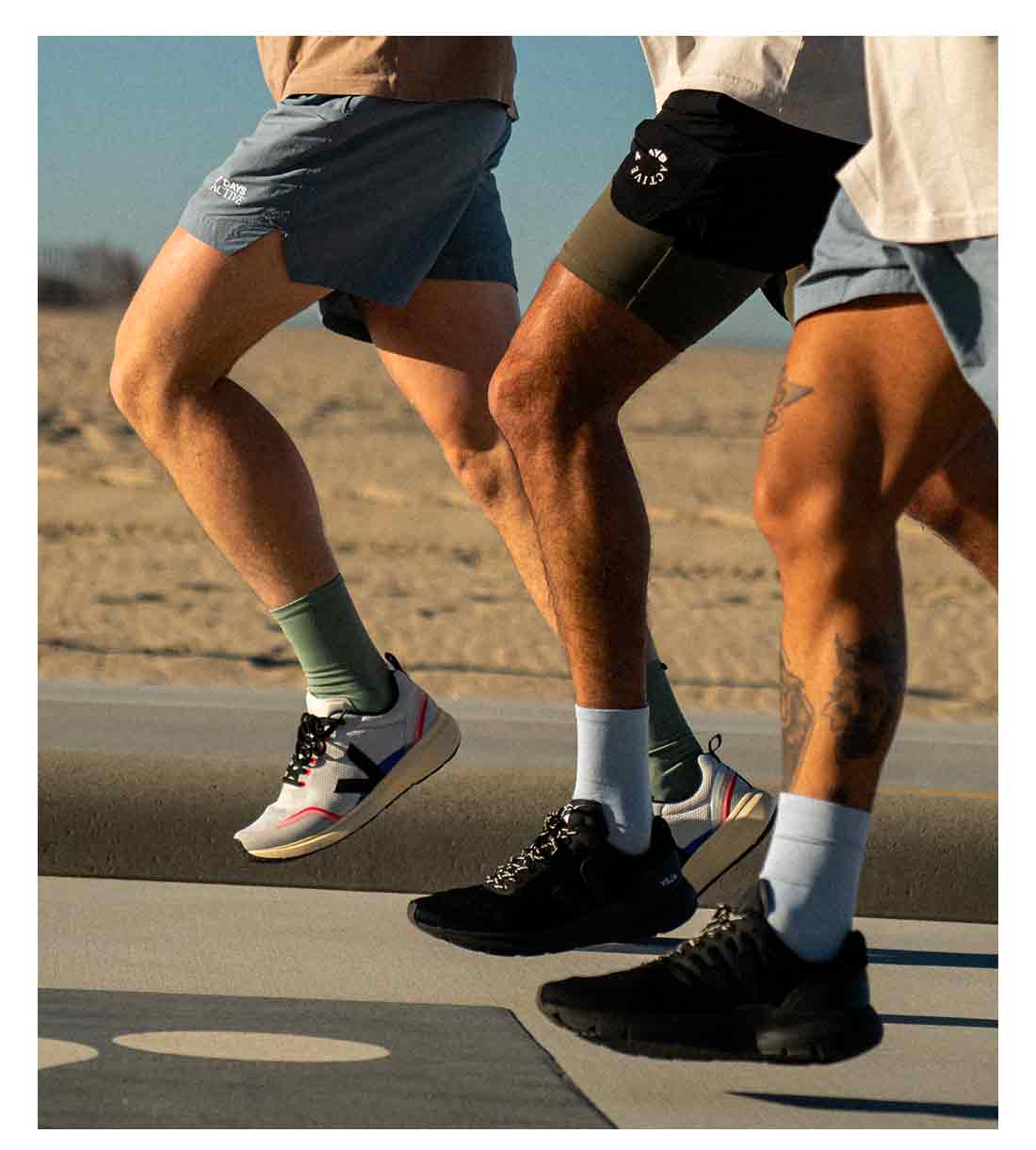 Fokus auf die Beine von drei Läufern, sie tragen VEJA-Laufschuhe